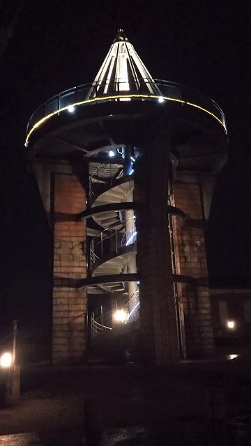 発電所美術館の展望台を撮影した写真。夜空の下、螺旋階段がライトアップされている。