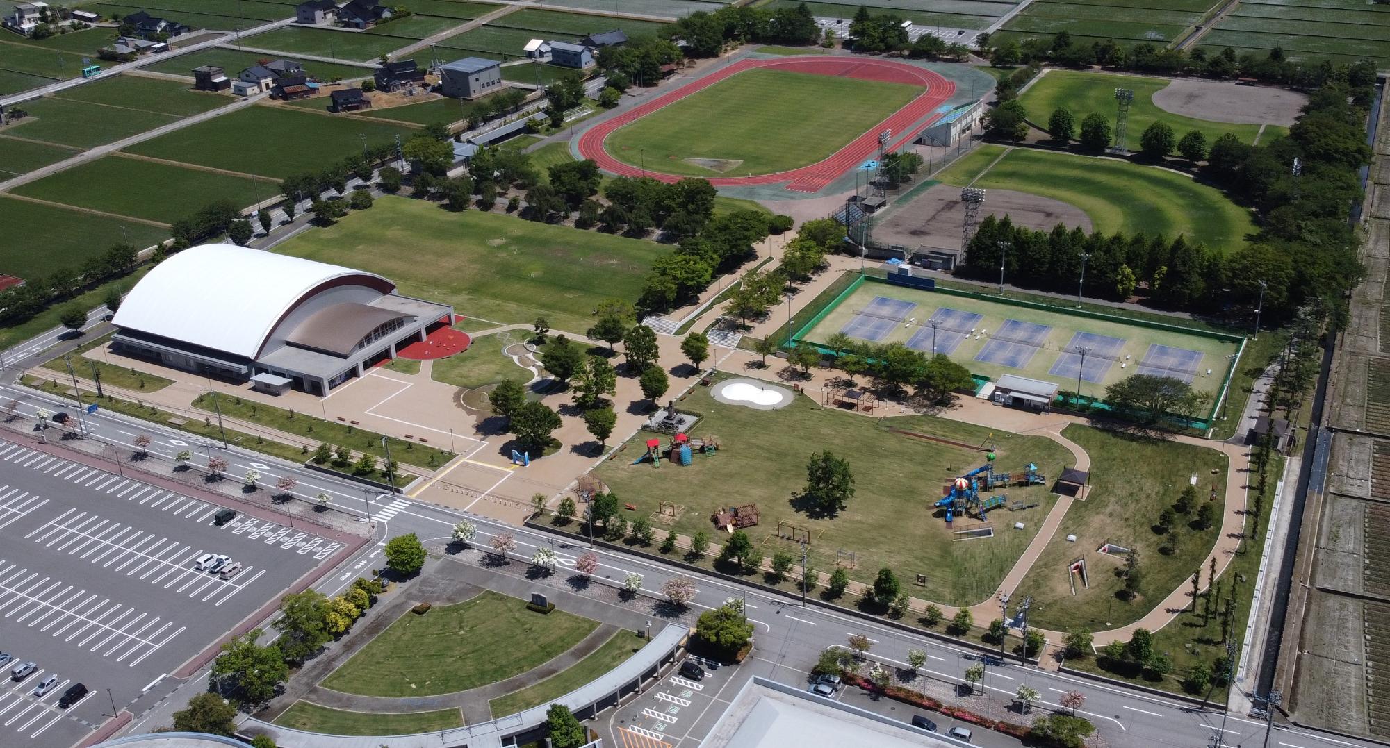 陸上競技場、野球場、テニスコートなどが備わった上空から撮影した入善運動公園の写真