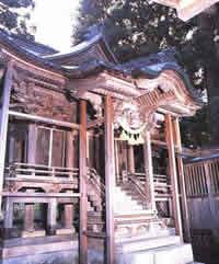 数段の上り階段と濡縁の手すりがみえる、斜め前から見た木造の神社の写真