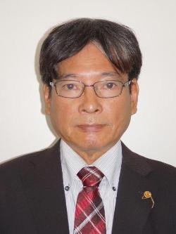スーツ姿にメガネをかけた松田俊弘議員の顔写真