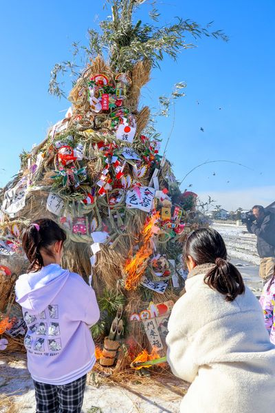 集めた正月飾りに着火する児童