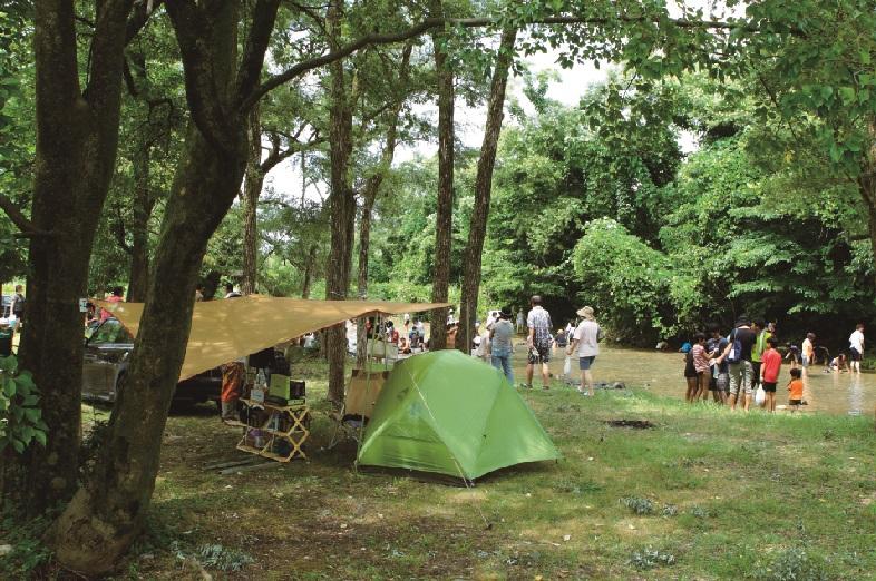 墓ノ木自然公園でテントを張ってキャンプを楽しんだり、黒部川で水遊びをしている人々の写真
