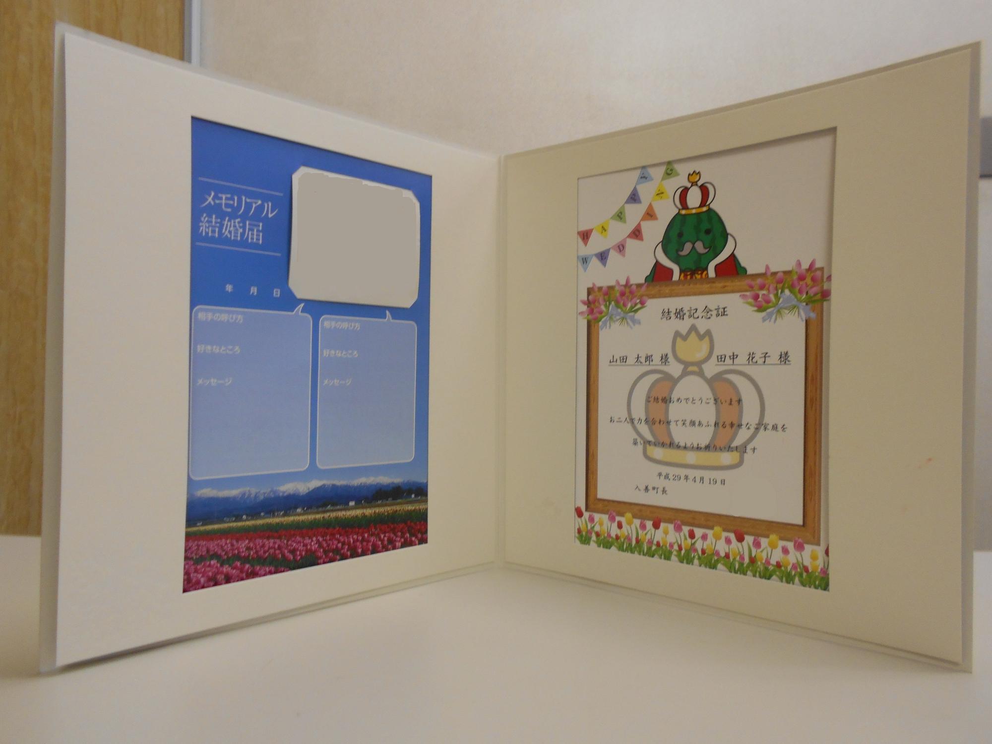 左側には二人の写真が載った「メモリアル結婚届」、右側にはジャンボール三世が書かれた賞状タイプの「結婚記念証」が載っている結婚記念パネルの写真
