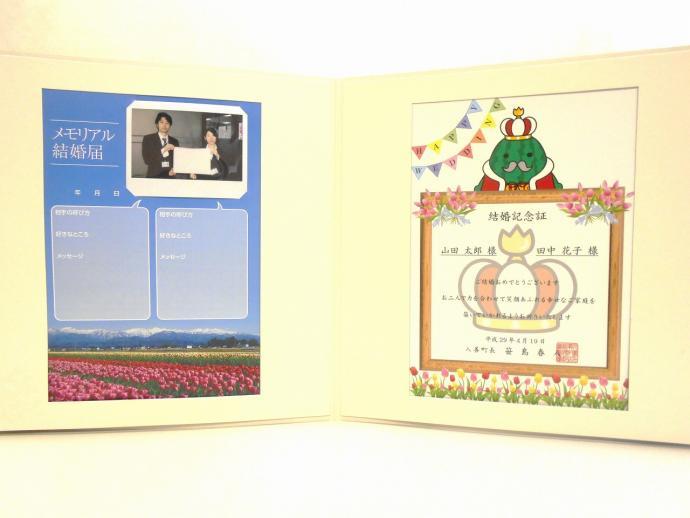 左側には二人の写真が載った「メモリアル結婚届」、右側にはジャンボール三世が書かれた賞状タイプの「結婚記念証」が載っている結婚記念パネルの写真