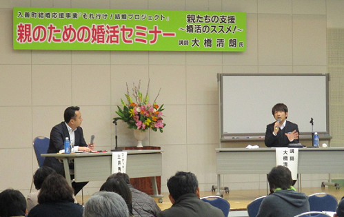 コーディネーターの土井氏がマイクで話しているのを講師の大橋氏が聞いている様子の写真